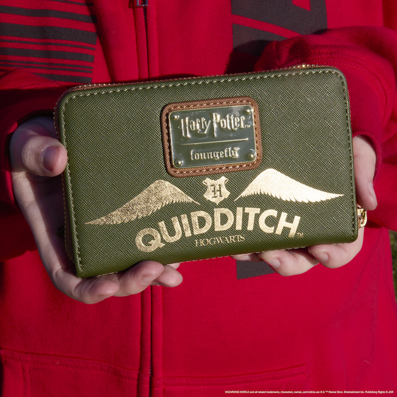 Image of two hands holding the Quidditch wallet, showing the back view, against a red sweater